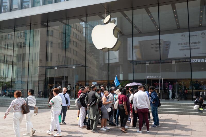 La gente pasa por una tienda de Apple en Shanghai, China.