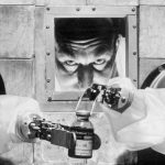 A 1956 scientist carefully bottles isotopes with robotic arms from behind a protective wall at the Radiochemical Centre, one of the largest pharmaceutical factories in the world.