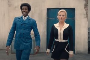 Gata in blue 1960s suit and Afro, Ruby in classic mini skirt and white boots