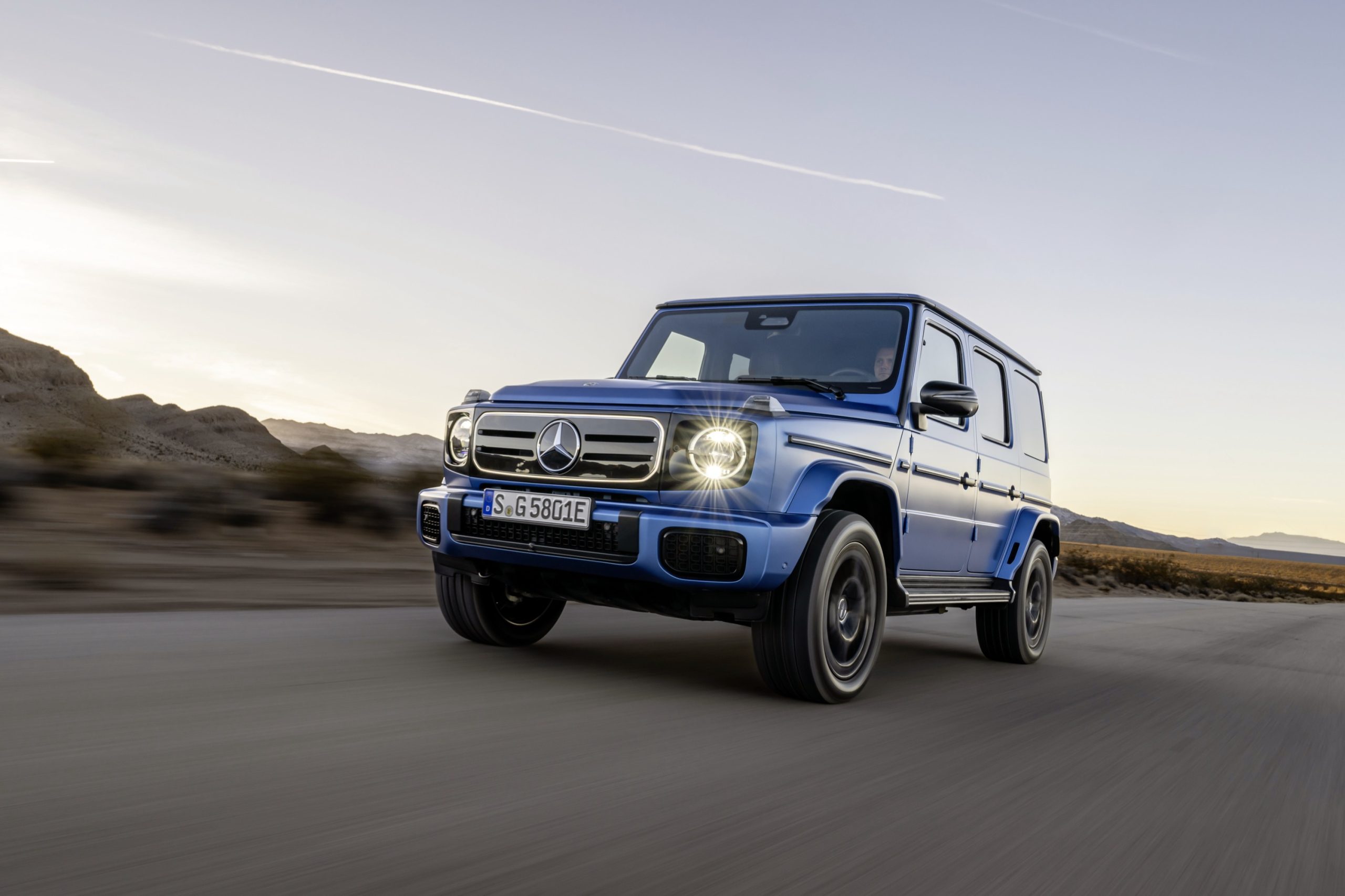 A blue Mercedes G-Wagon drives towards the camera
