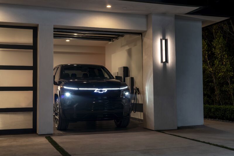 2024 Chevrolet Silverado EV RST in a residential garage at dusk with GM Energy products.