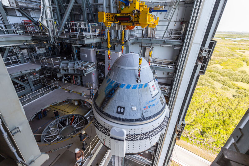 Boeing's Starliner spacecraft is lifted to be placed atop an Atlas V rocket for its first crewed launch.
