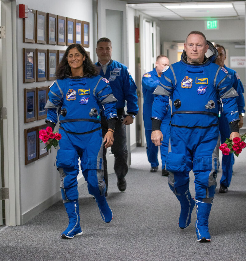 Astronauts Suni Williams and Butch Wilmore, wearing their Boeing spacesuits, leave NASA's crew quarters during a launch attempt May 6.