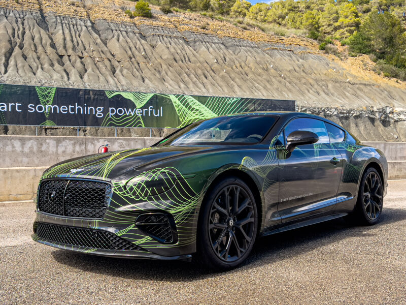 A Bentley Continental GT Speed wearing a camouflage wrap, in the pit lane of a race track
