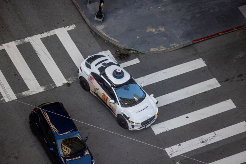 A Waymo self-driving car in downtown San Francisco on Bush and Sansome Streets as it drives and transports passengers.