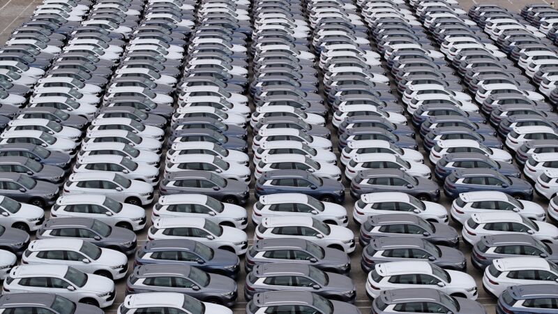 The photo is filled with row after row of new SUVs, all painted white or grey.