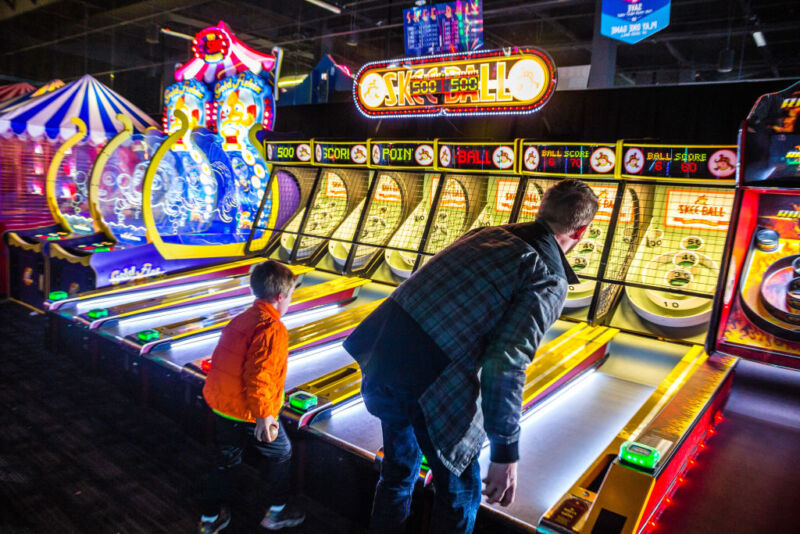 It's a good thing this kid is too young to bet on Skee-Ball, because his dad is getting <em>beat</em>.
