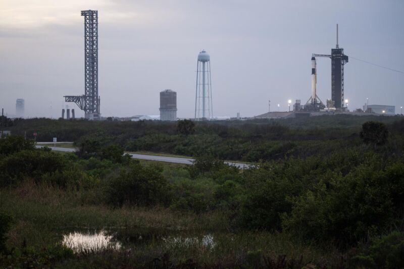 A torre Starship da SpaceX (à esquerda) no Complexo de Lançamento 39A supera a plataforma de lançamento do foguete Falcon 9 (à direita).