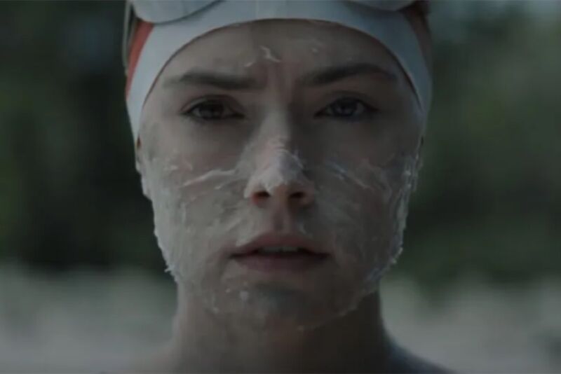 close up of Daisy Ridley in swim cap with grease on her face