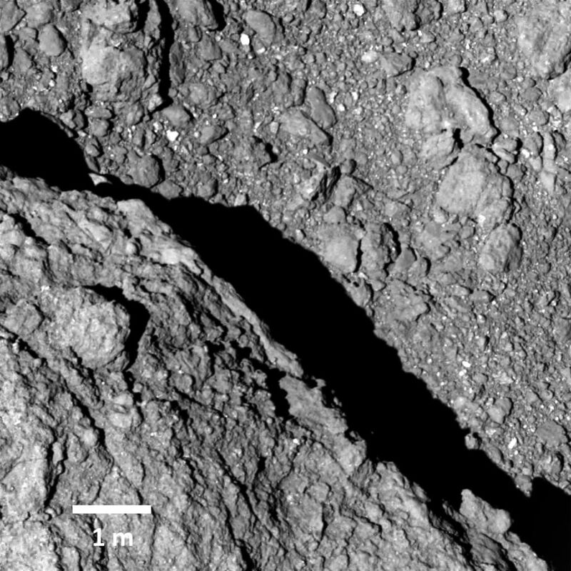 Imagen gris de una superficie compleja formada por muchas rocas pequeñas unidas por polvo.