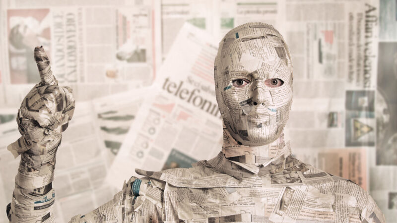 A man covered in newspaper.