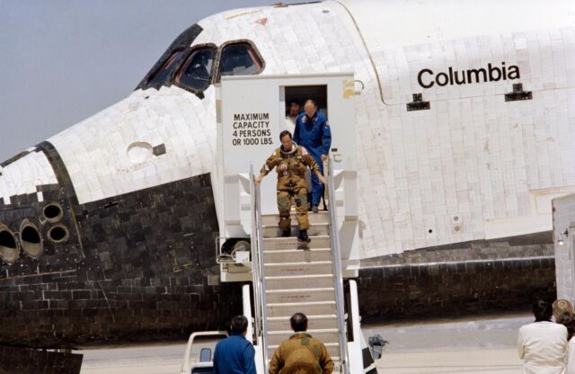 Astronaut Bob Crippen walks down stairs to disembark from the space shuttle <em>Columbia</em> following its first landing on April 14, 1981, at Edwards Air Force Base, California.