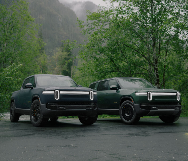 A Rivian R1T and R1S parked together in a forest