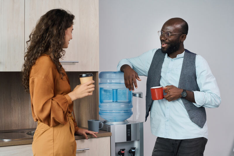 Man and woman talking at an office water cooler