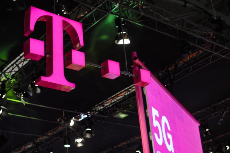 A large T-Mobile logo and a 5G poster hanging above a conference hall.