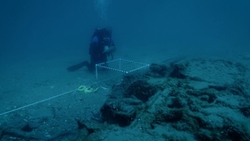 Michigan's State Maritime Archaeologist Wayne R. Lusardi takes notes underwater at the wreckage.