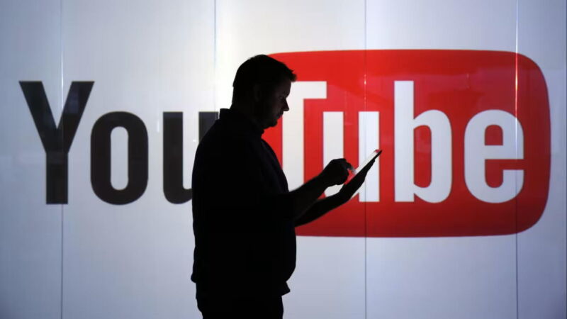 Man using phone in front of YouTube logo