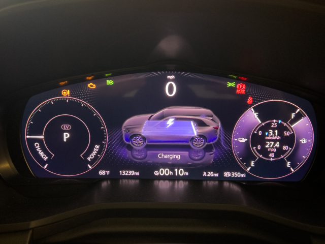 Mazda CX-90 PHEV main display showing charging status. The battery is at 99 percent and needs another 10 min to get to 100