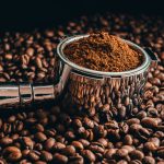 Close-up of coffee beans with roasted beans on table