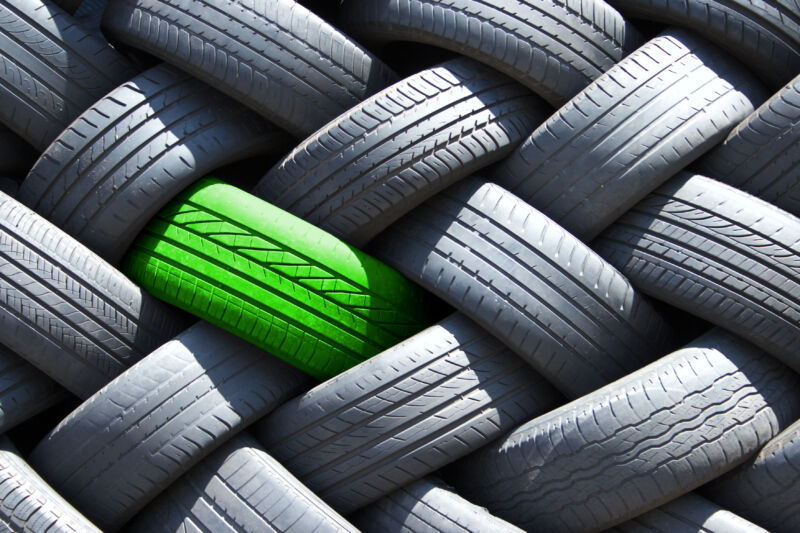 Single green tire in a stack of tires