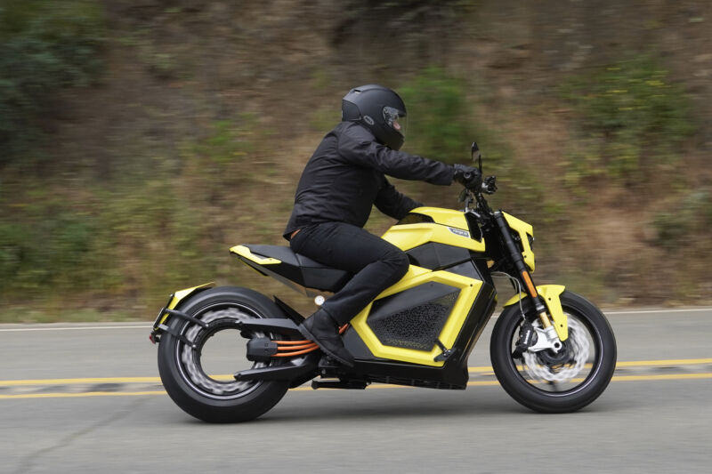 A man on a yellow electric motorcycle