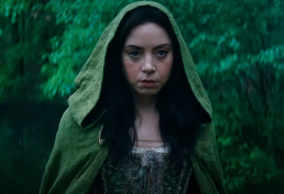 woman with long dark hair wearing a hooded green robe