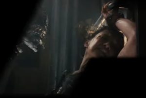 xenomorh head emerging from left frame while a horrified woman cowers in the right frame