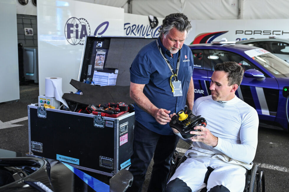 Formula E team owner Michael Andretti (L) and Robert Wickens (R) examining the Formula E steering wheel. 