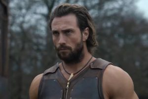 close up of well-muscled bearded man glowering in the woods