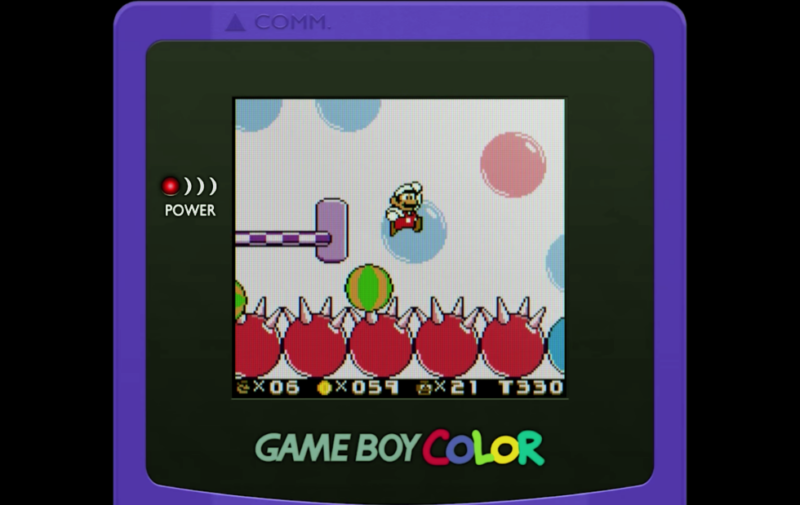 Super Mario Land 2 en couleur, avec Mario sautant par-dessus des boules pointues.