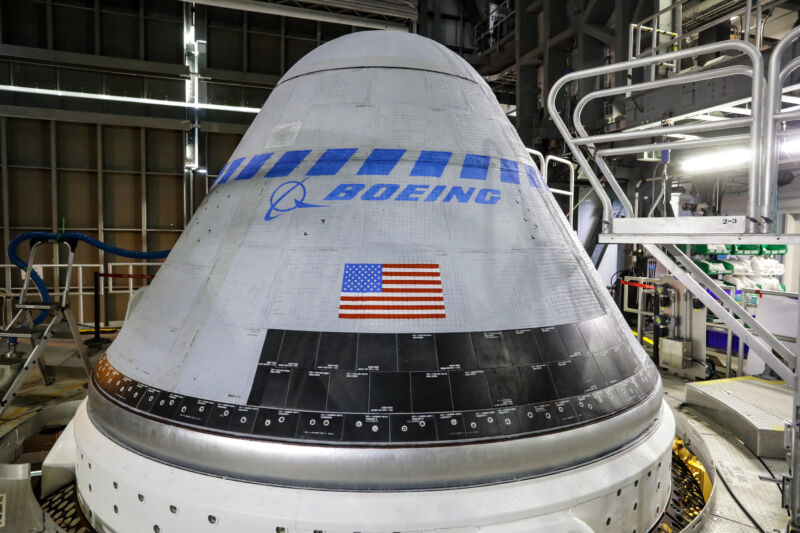 A Starliner spacecraft mounted ⁢on top of an Atlas V rocket before an unpiloted test flight in 2022.