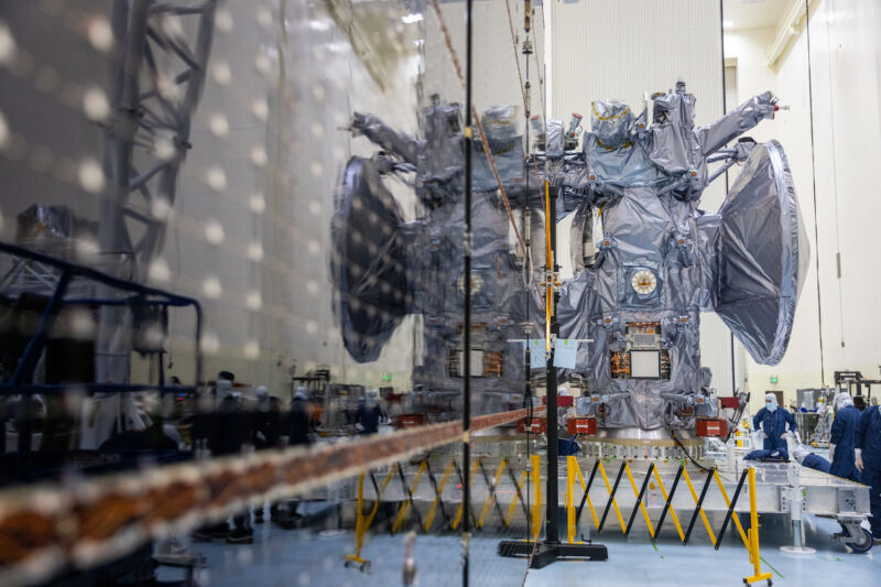 Het grootste deel van NASA's Europa Clipper-ruimtevaartuig wordt weerspiegeld in een van de inzetbare zonnepanelenvleugels van de missie tijdens tests in het Kennedy Space Center in Florida.