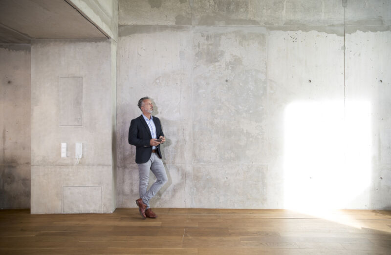 Business-like man standing in a concrete loft space