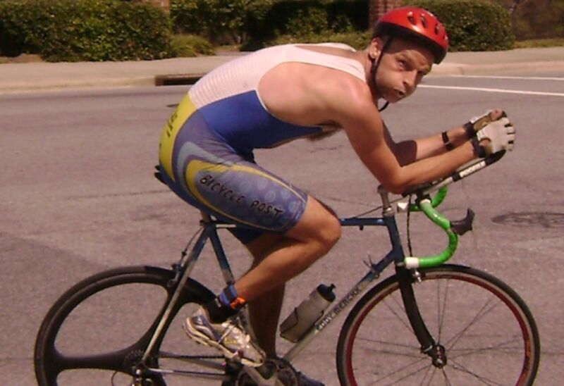 man in bicycle in cycling shorts and helmet