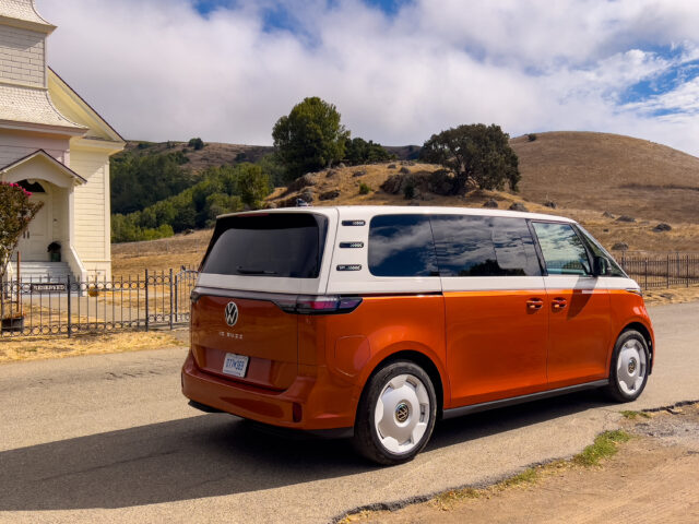 A VW ID Buzz parked next to a small church in a rural Californian village.