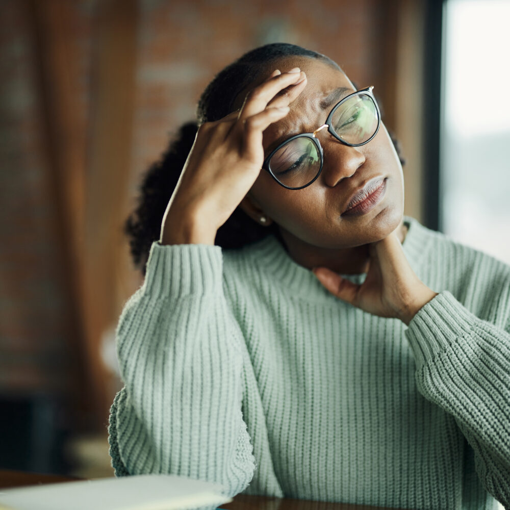 Displeased African American woman holding her head in pain.