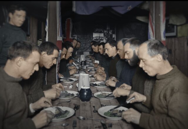 Crew members sit down for a Midwinter feast on the Endurance, five months after the ship became stuck in ice and four months before the crew was forced to evacuate.