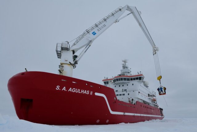 Team members are lowered onto the ice from the crane on the S.A. Agulhas II.