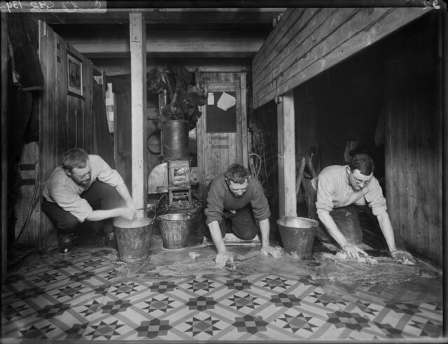 crew members (left to right): James Wordie, Alfred Cheetham and Alexander Macklin clean the linoleum floor of the galley on the Endurance.