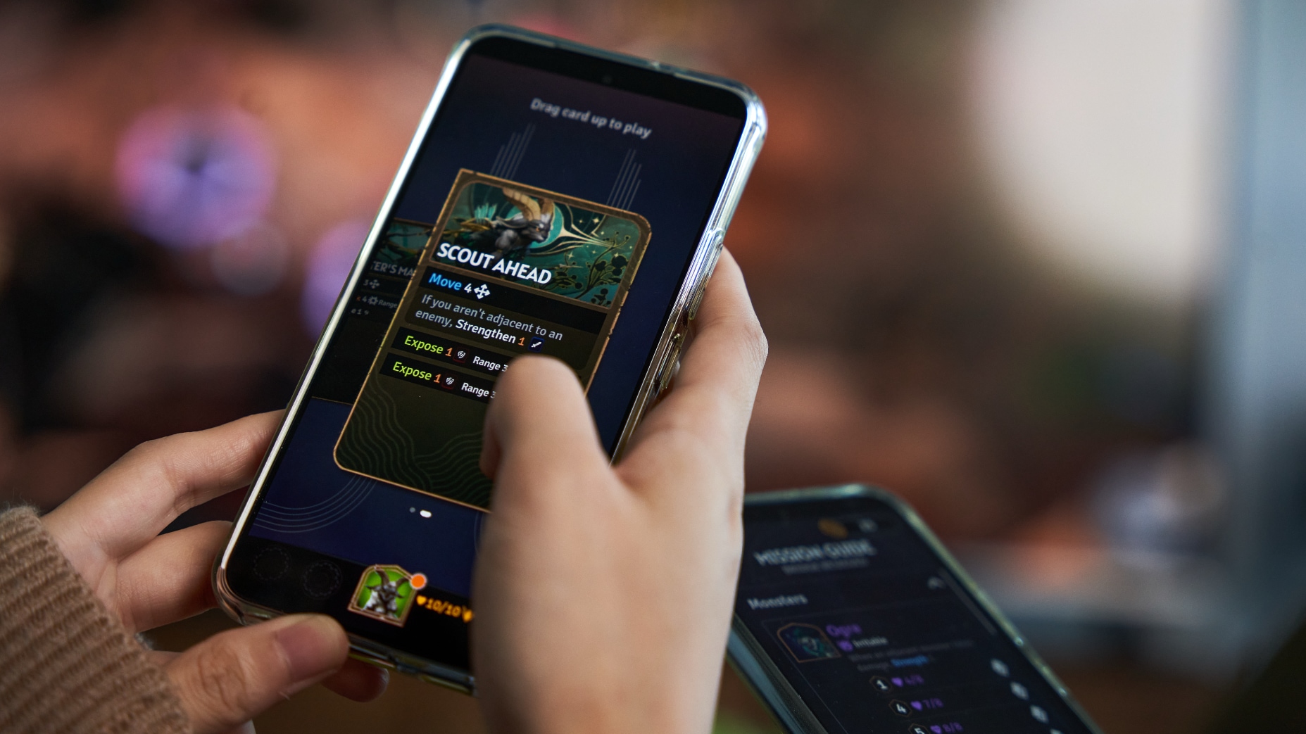 Person holding phone, using it to read an action card in Sunderfolk full of moves, attacks, and descriptions.