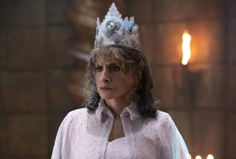 Middle aged woman dressed as Glinda the Good Witch, all in white with a crown on her head