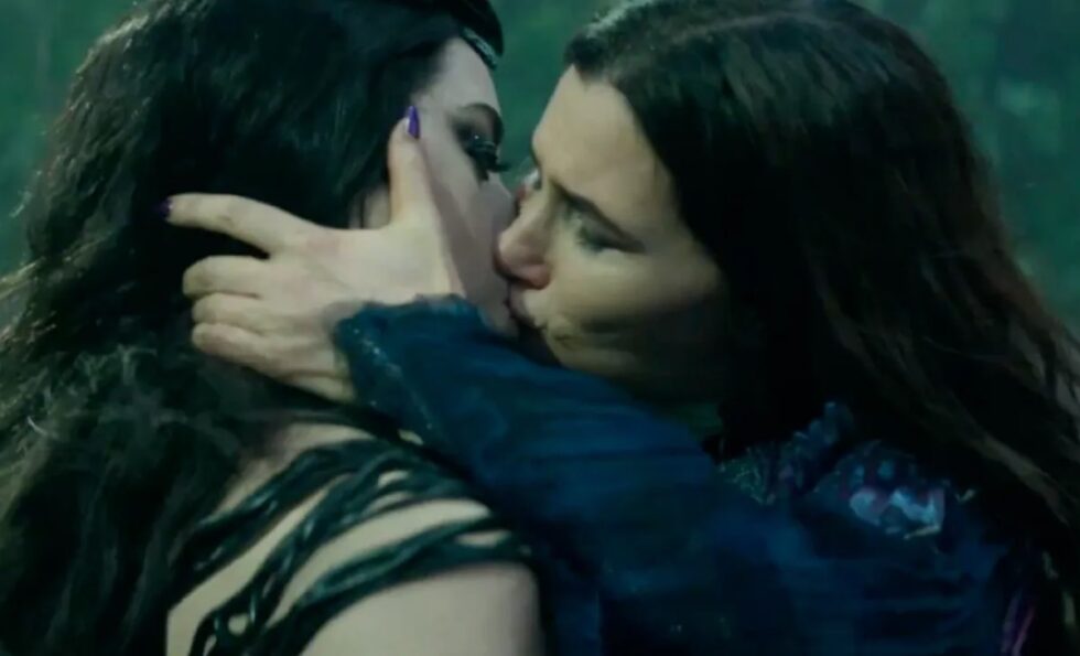 two dark haired women kissing passionately.