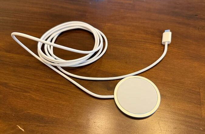 A charger with cable sits on a table