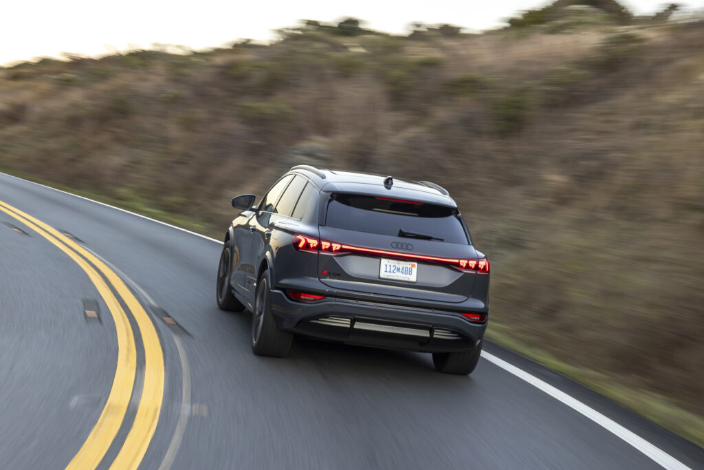 A dark grey Audi SQ6 drives away from the camera