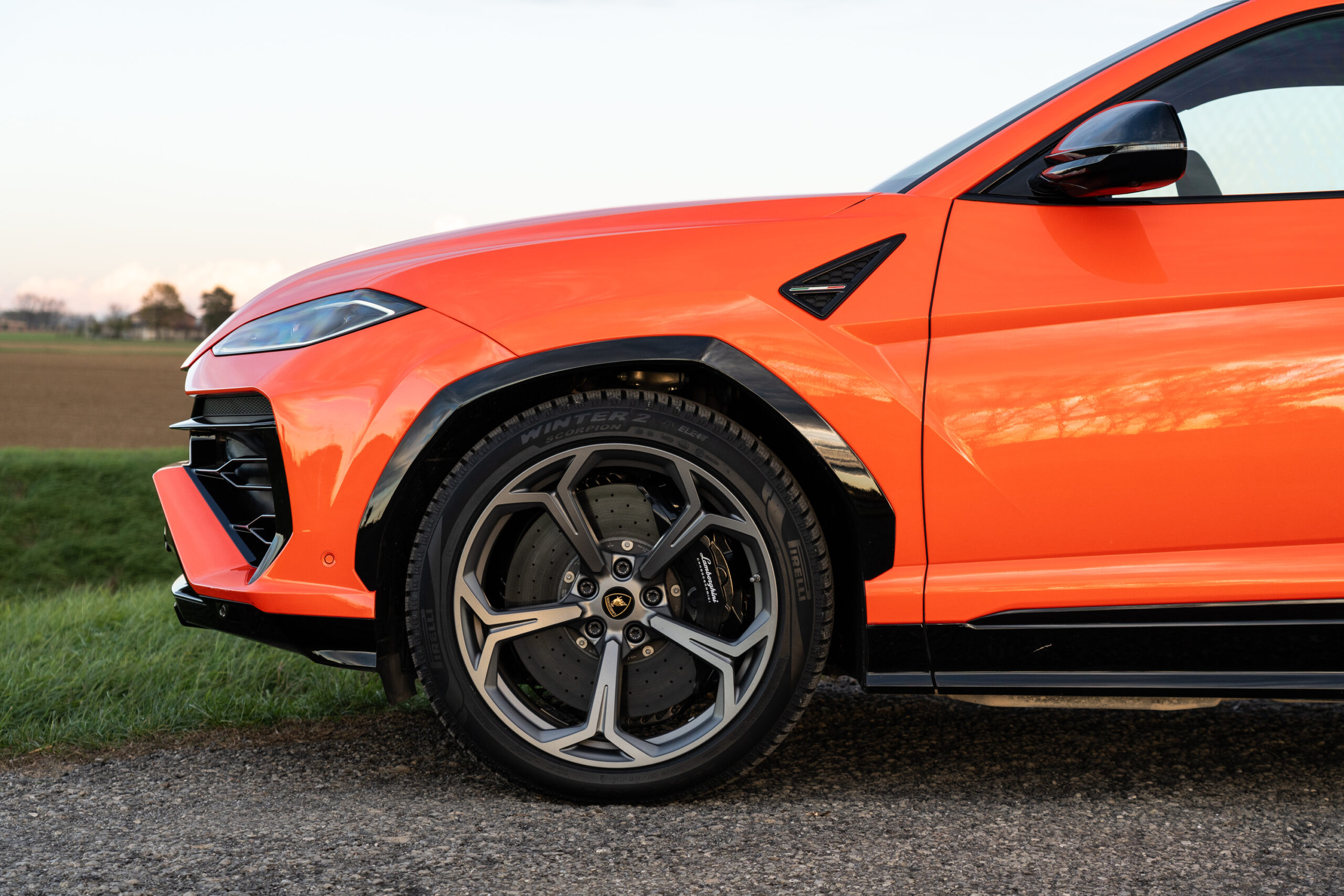 the front half of an orange Lamborghini Urus