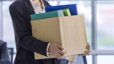Person holding a box with office supplies