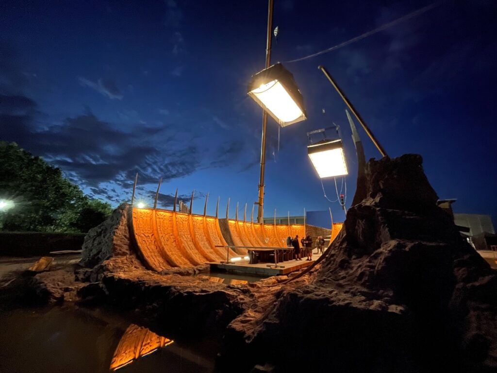 shot of a set at night with overhead lights on cranes.