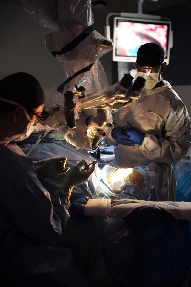 surgeons operating on the brain of a patient