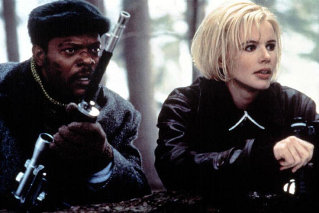 black man and blonde woman crouching in the snow holding guns.