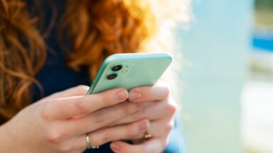 A woman holding a cell phone in her hands